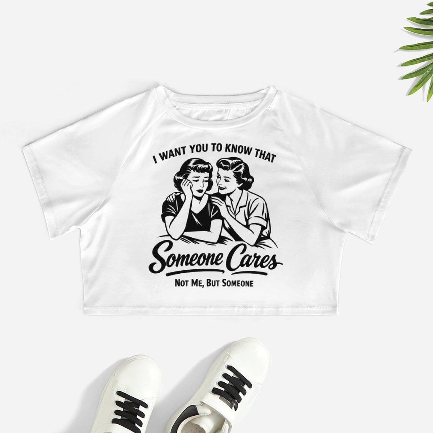 lat lay view of a premium white short sleeve navel crop top with a crew neck and stretchable polyester fabric showing a viral sarcastic graphic design.