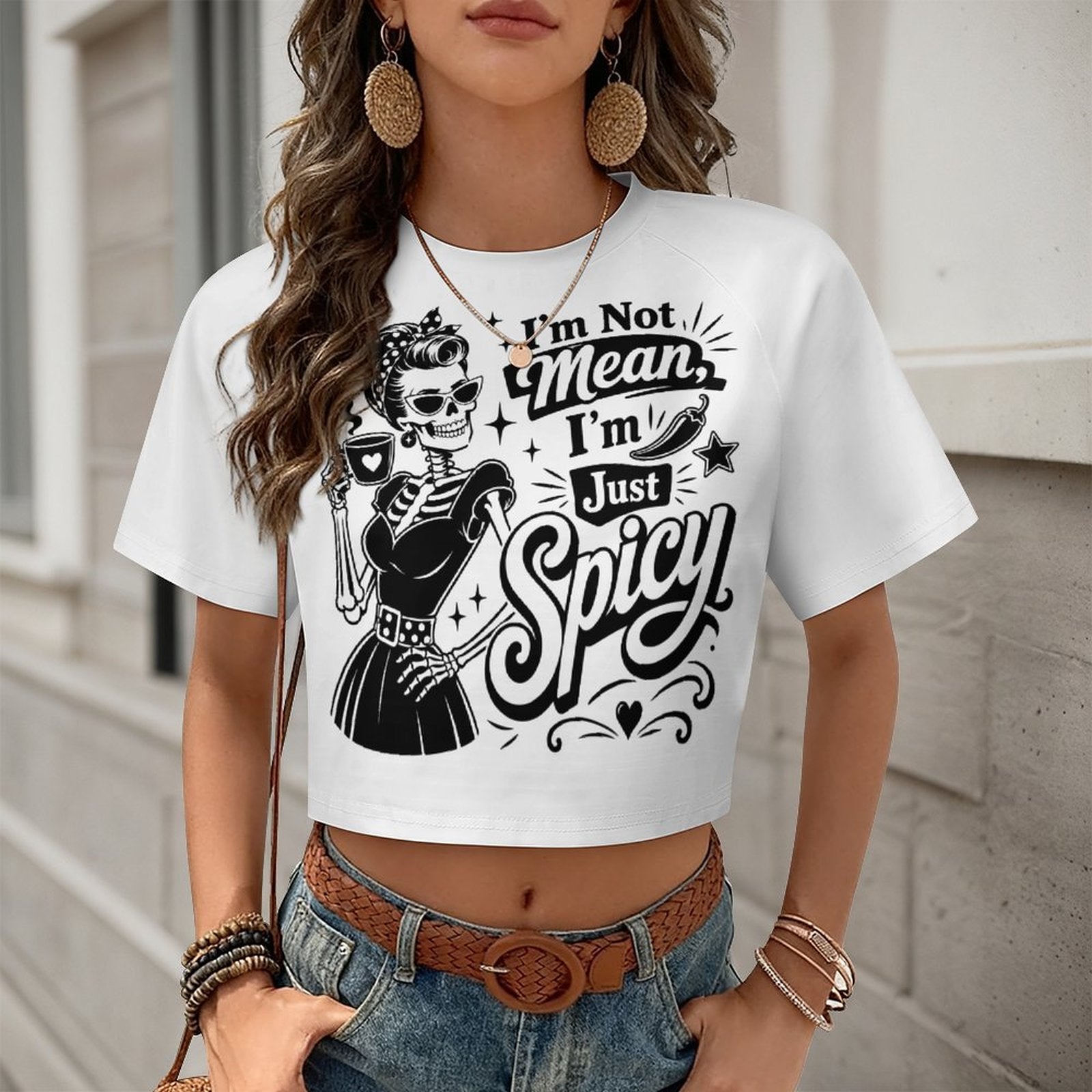 A front view of a white women's cropped t-shirt featuring a color-block short sleeve design and a sassy black 'Not Mean I'm Spicy' slogan text graphic.