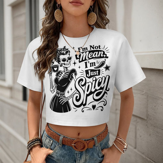 A front view of a white women's cropped t-shirt featuring a color-block short sleeve design and a sassy black 'Not Mean I'm Spicy' slogan text graphic.
