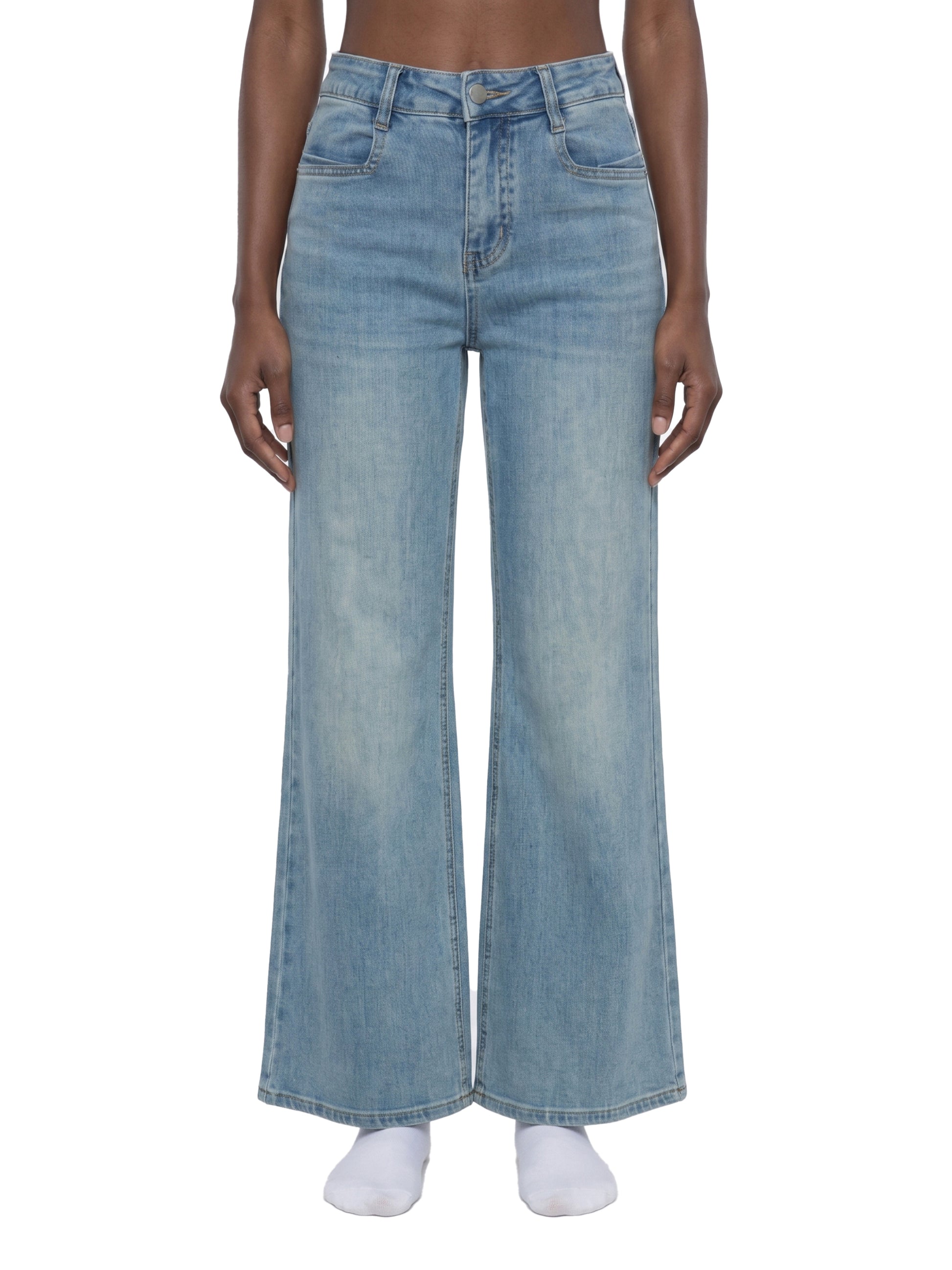 Frontview of a model wearing women's light blue flared jeans, showcasing the mid-waist fit, classic pocket placement, and straight wide-leg silhouette.