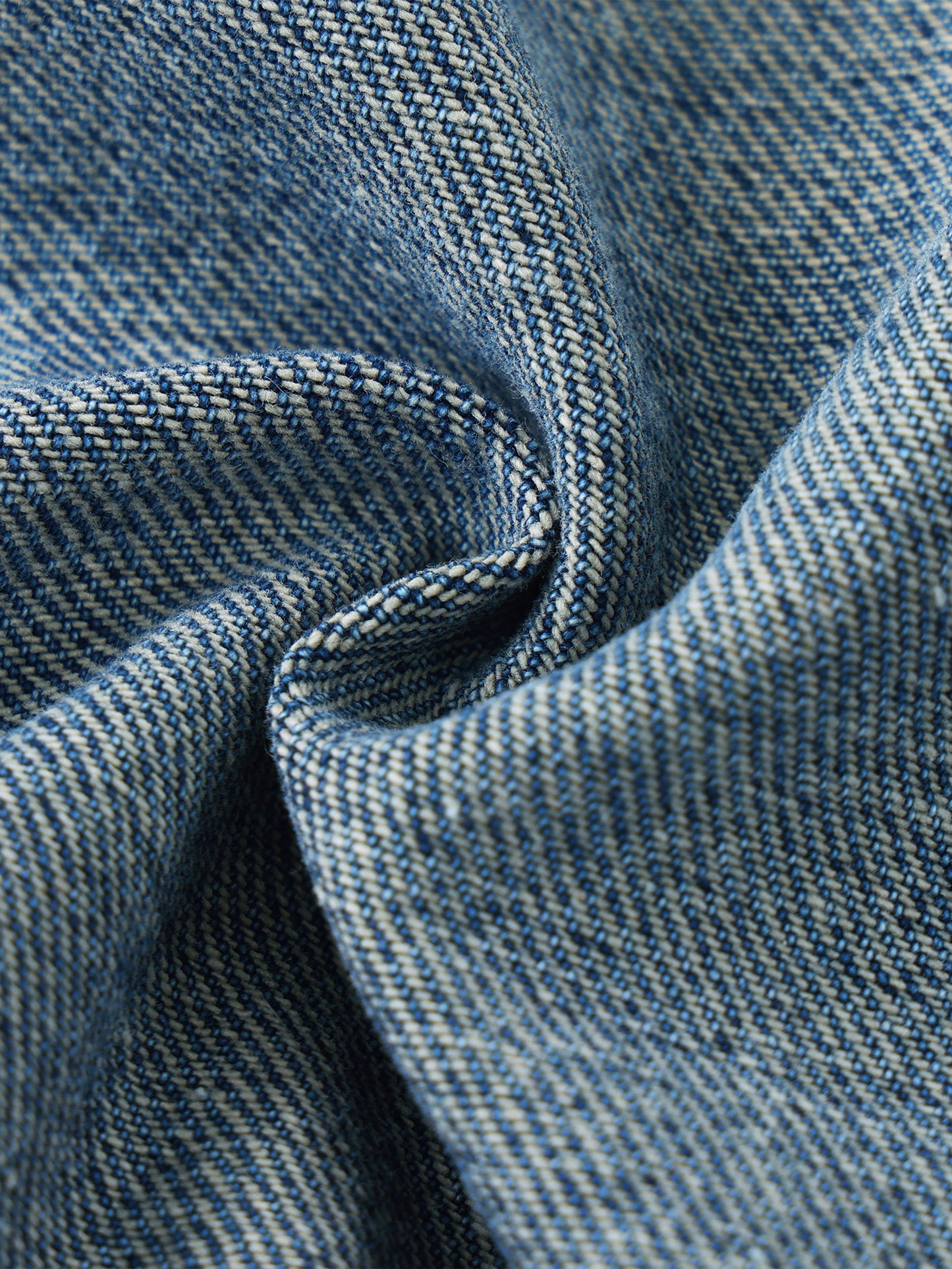 Macro close-up view of the premium heavyweight vintage wash blue denim fabric, highlighting the authentic textured weave and yarn fibers.