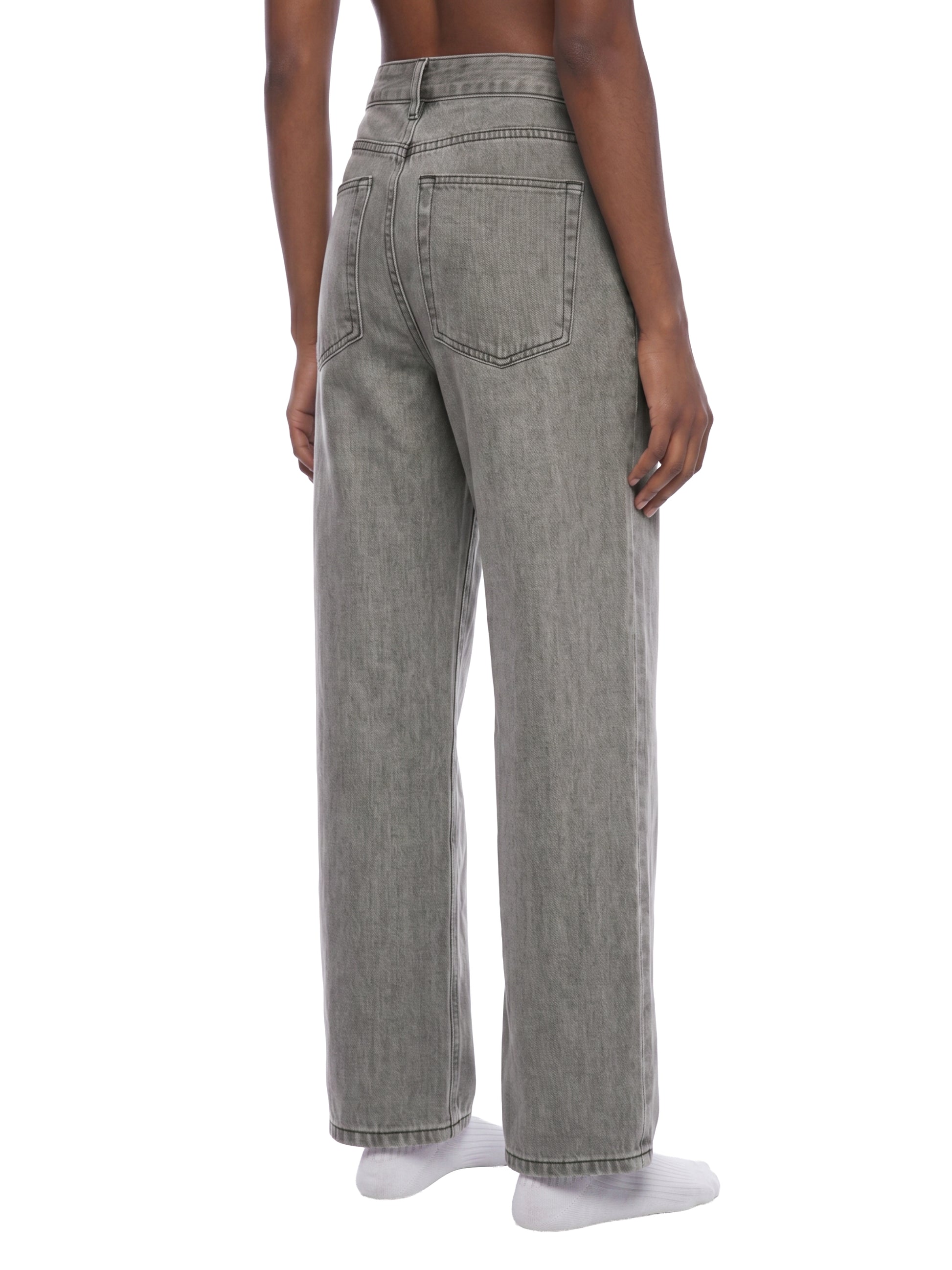 Rear view of a model wearing unisex light gray vintage wash straight leg jeans, showcasing the classic back pockets, relaxed fit, and straight streetwear silhouette.