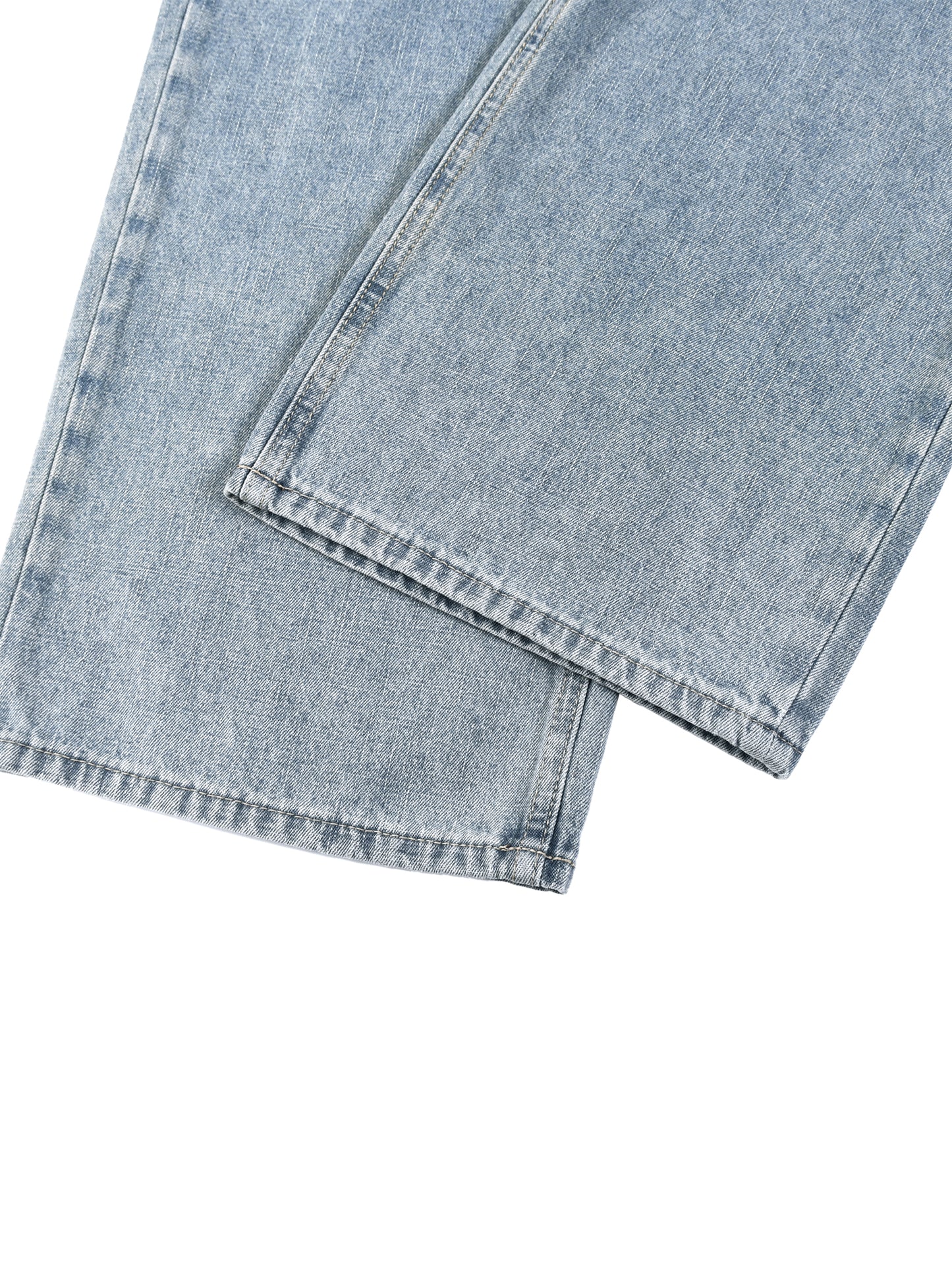 Close-up view of the clean side seam and durable hem stitching on unisex light gray vintage wash straight leg jeans.