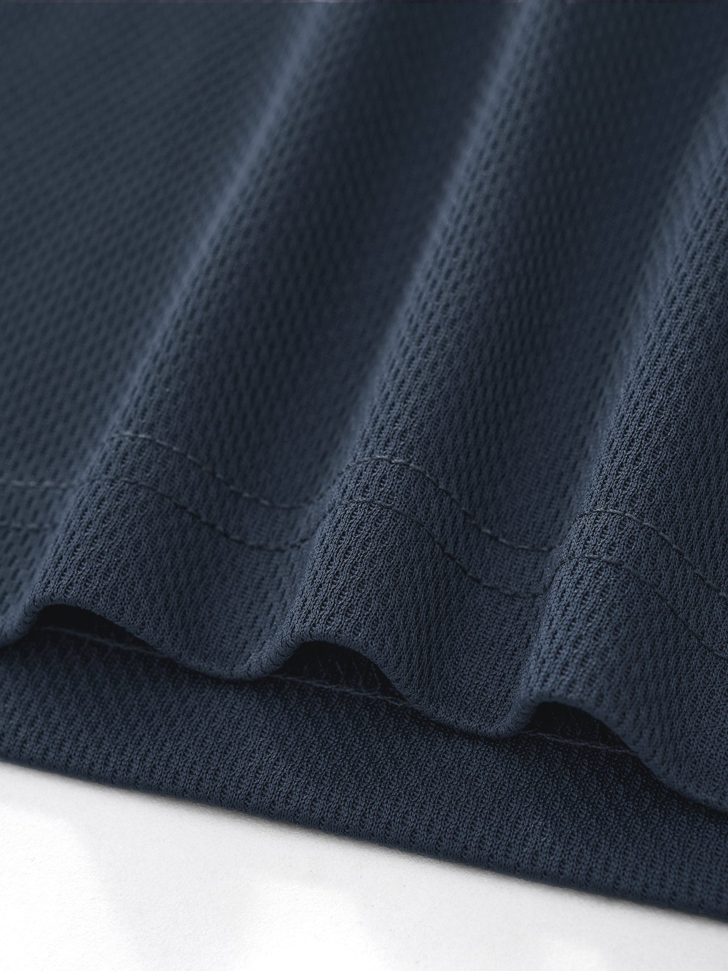Macro close-up view of the dark gray 100% polyester fabric texture on the BTS V cropped jersey, highlighting the tight waffle knit weave and durable hem stitching.
