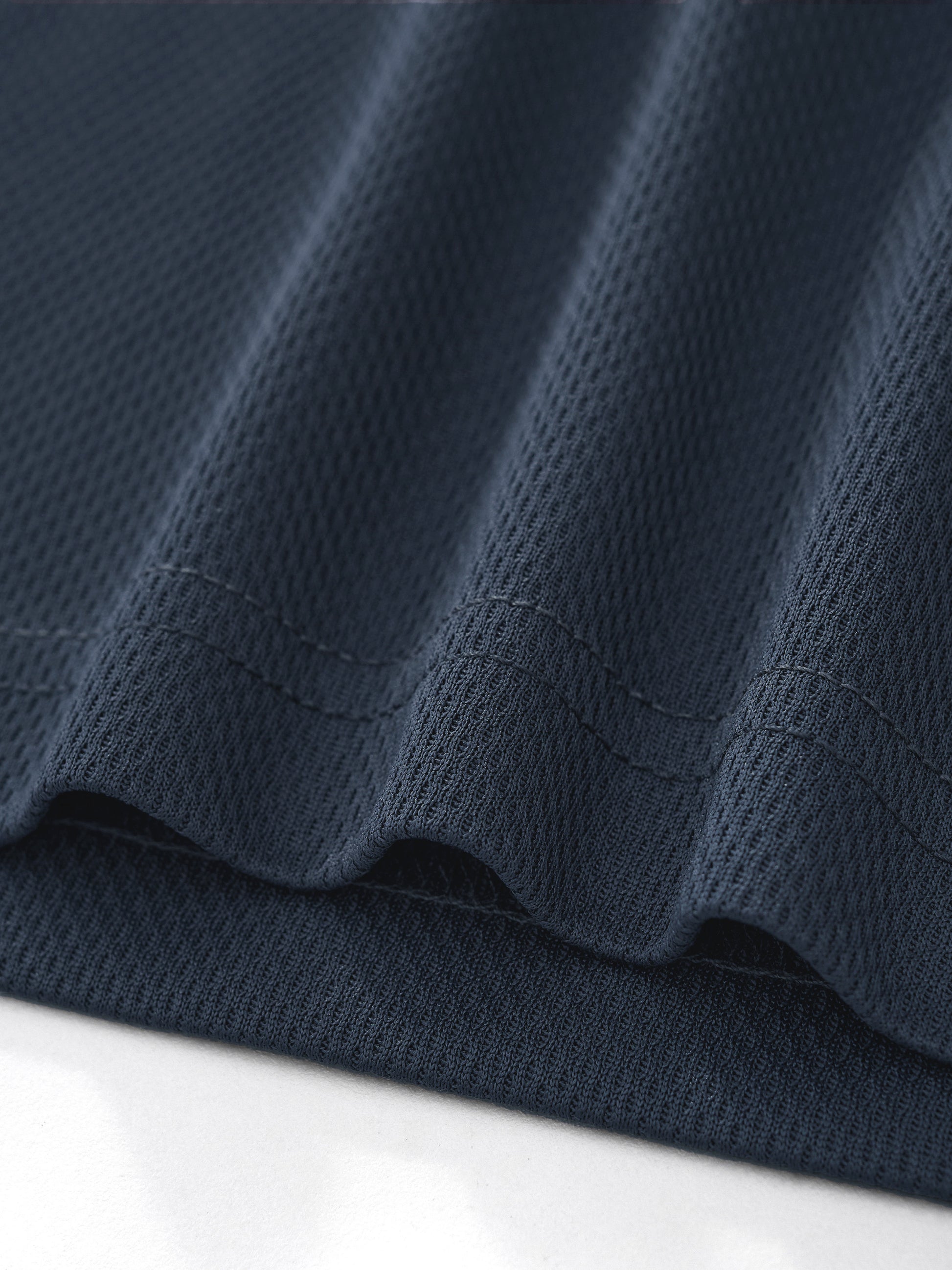 Macro close-up view of the dark gray 100% polyester fabric texture on the BTS V cropped jersey, highlighting the tight waffle knit weave and durable hem stitching.